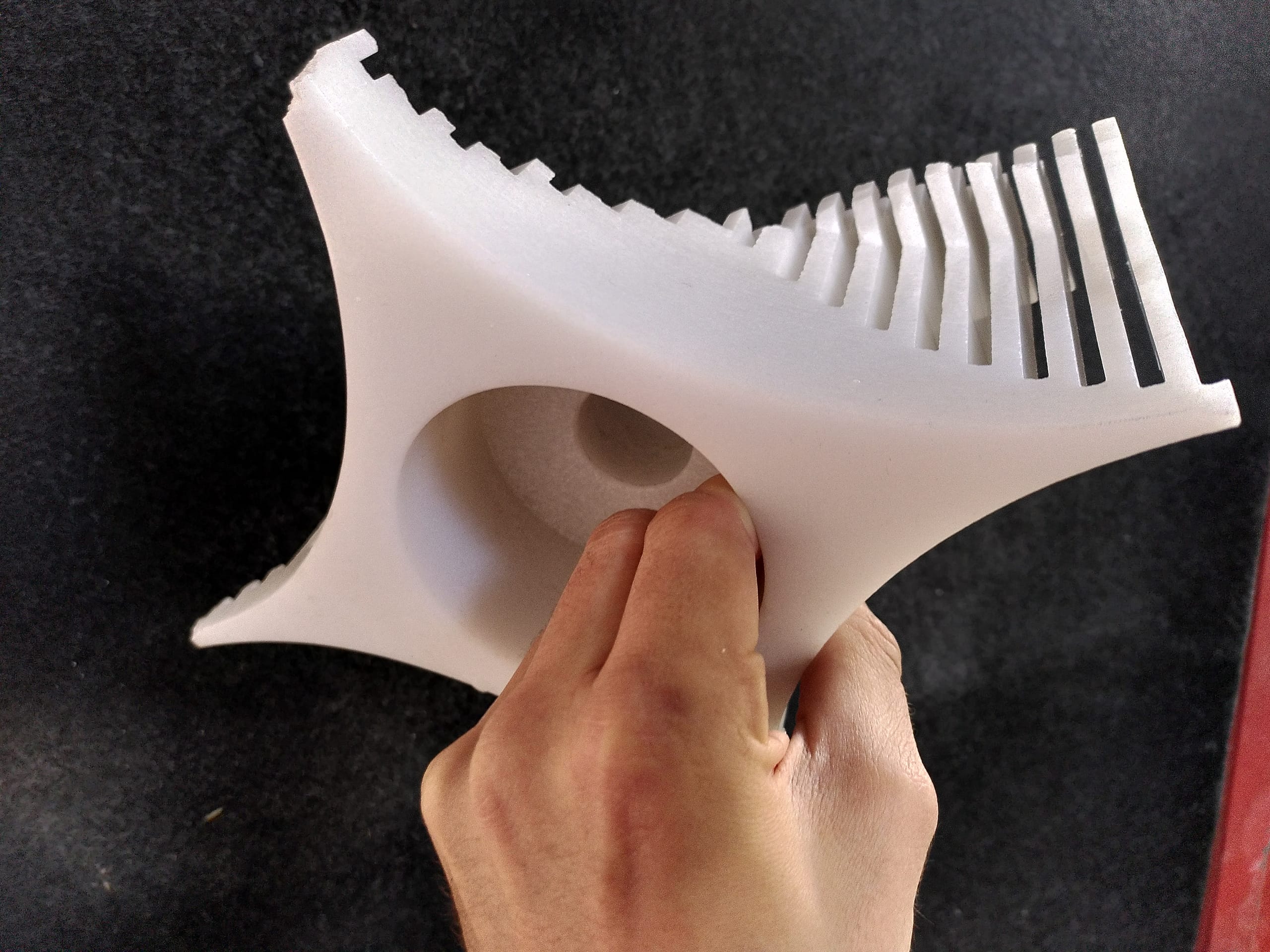Die Lampe in einer Hand, der geriffelte Rand und die runde Öffnung für die Fassung sichtbar
