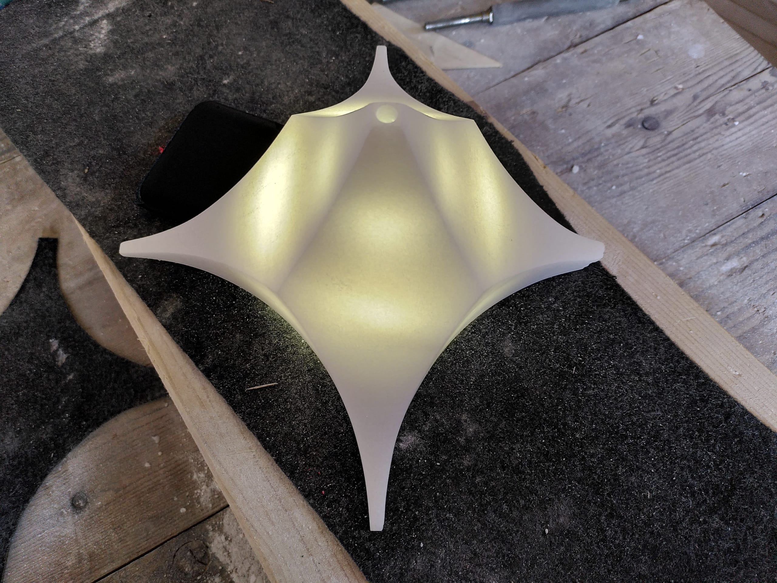 Die Lampe von innen beleuchtet, das Licht zeigt die gewölbten Flächen zwischen den Zacken